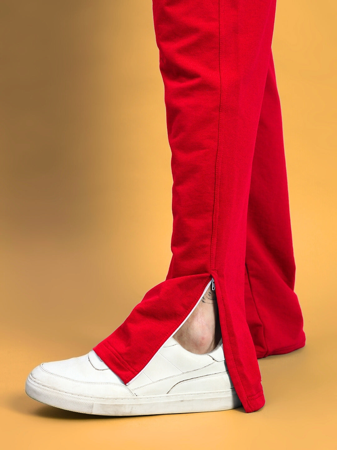 Red Hershey side slit joggers with white sneakers, close-up view highlighting the convenient side zipper.