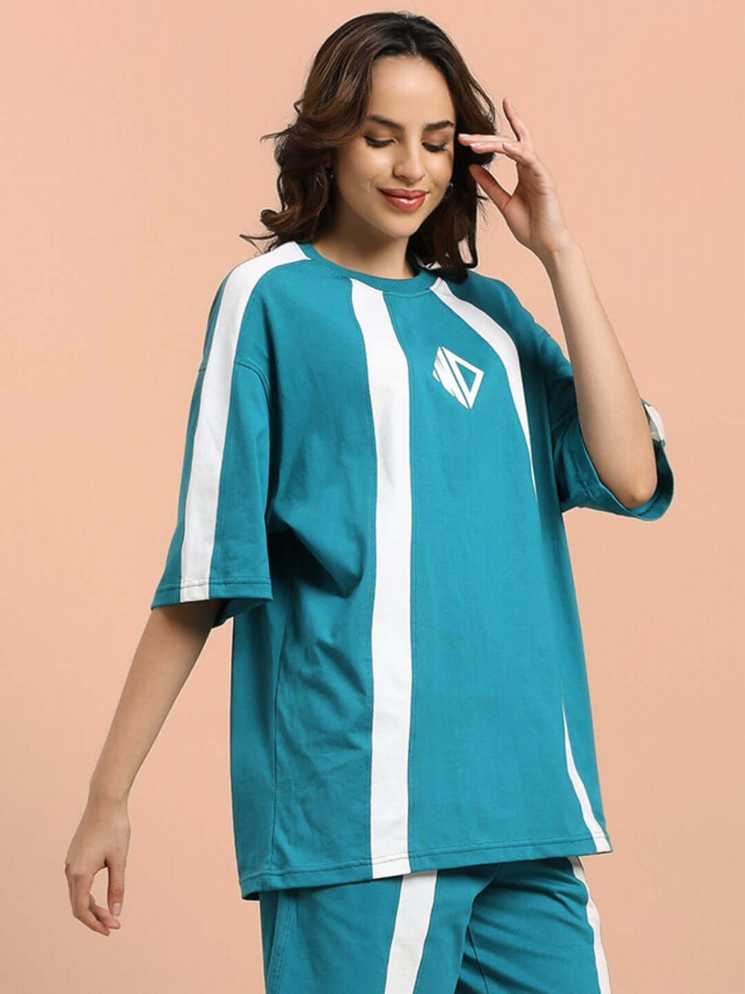 Women's teal oversized T-shirt made from premium cotton French terry with white stripes, bio-washed for softness, worn by a model.