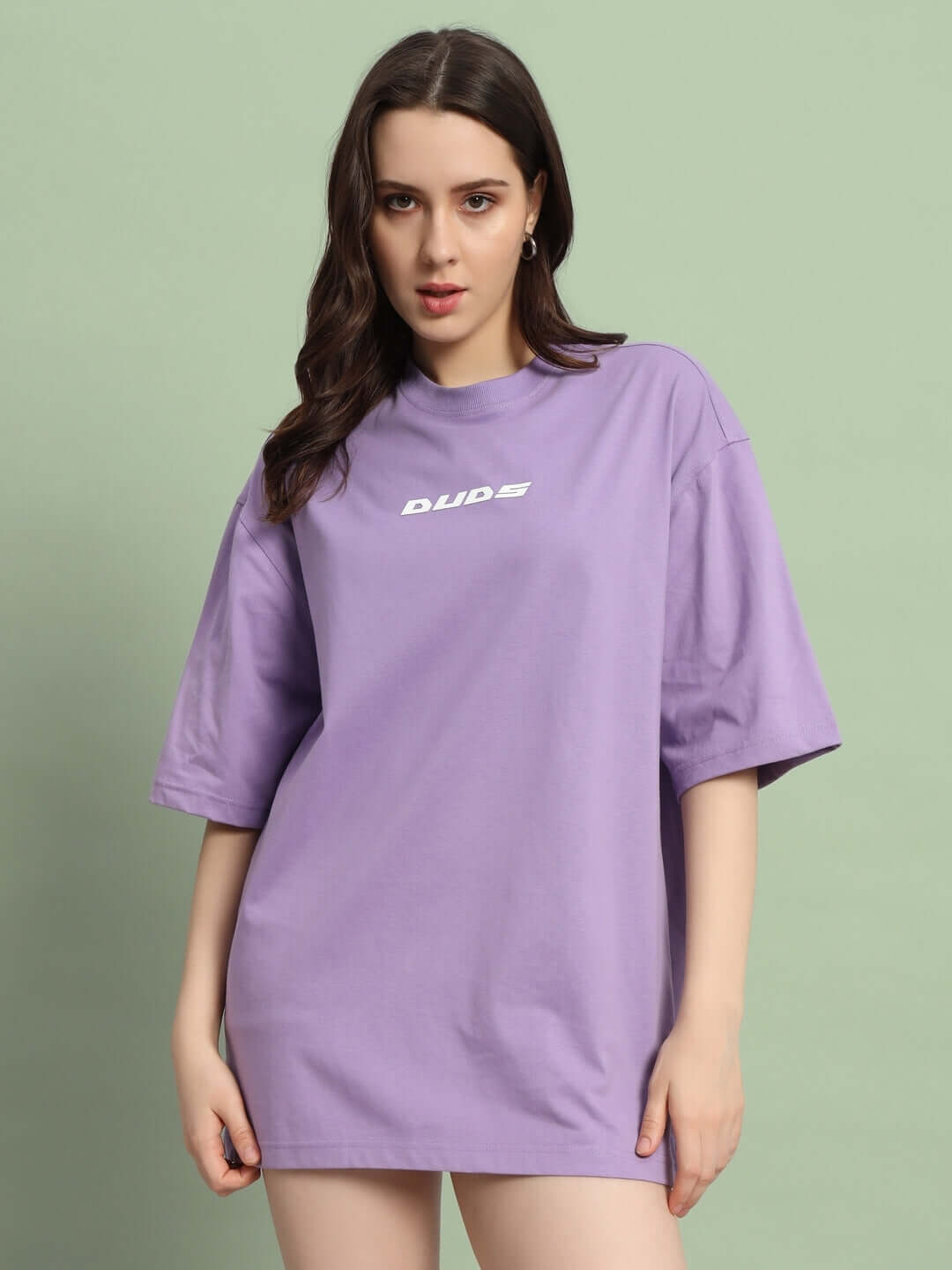 Woman wearing women's limited edition over-sized lavender t-shirt by DUDS, showcasing relaxed fit and casual style.