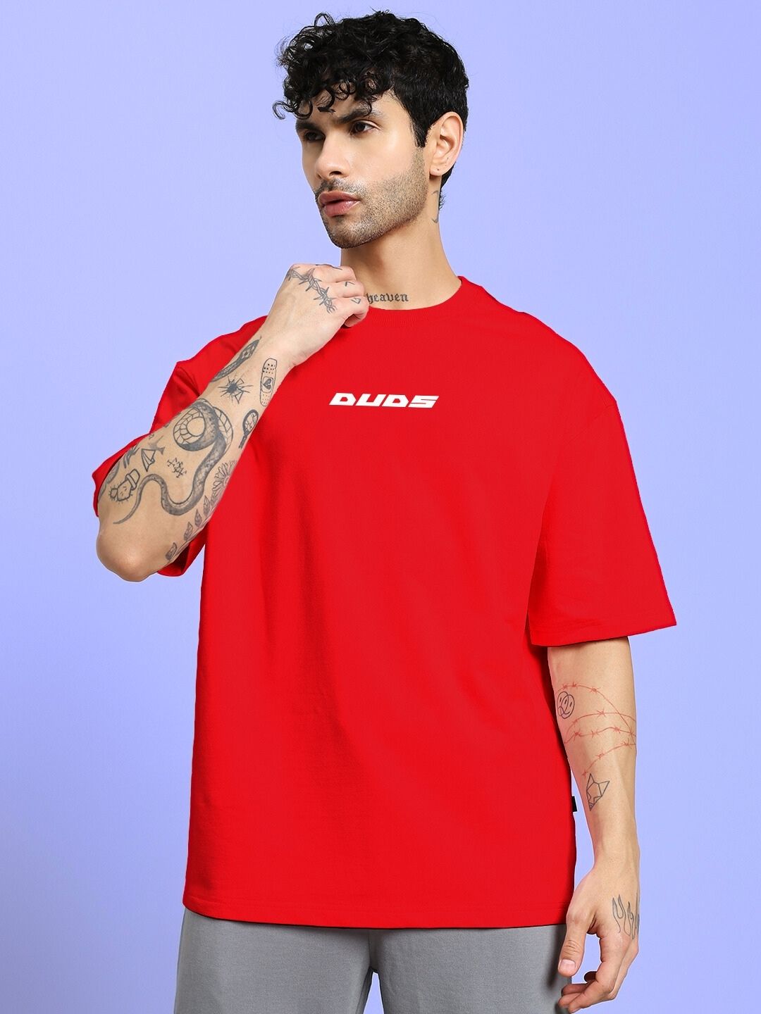 Person wearing CYBERPUNK OVER-SIZED T-SHIRT RED with tattoos in a blue background.