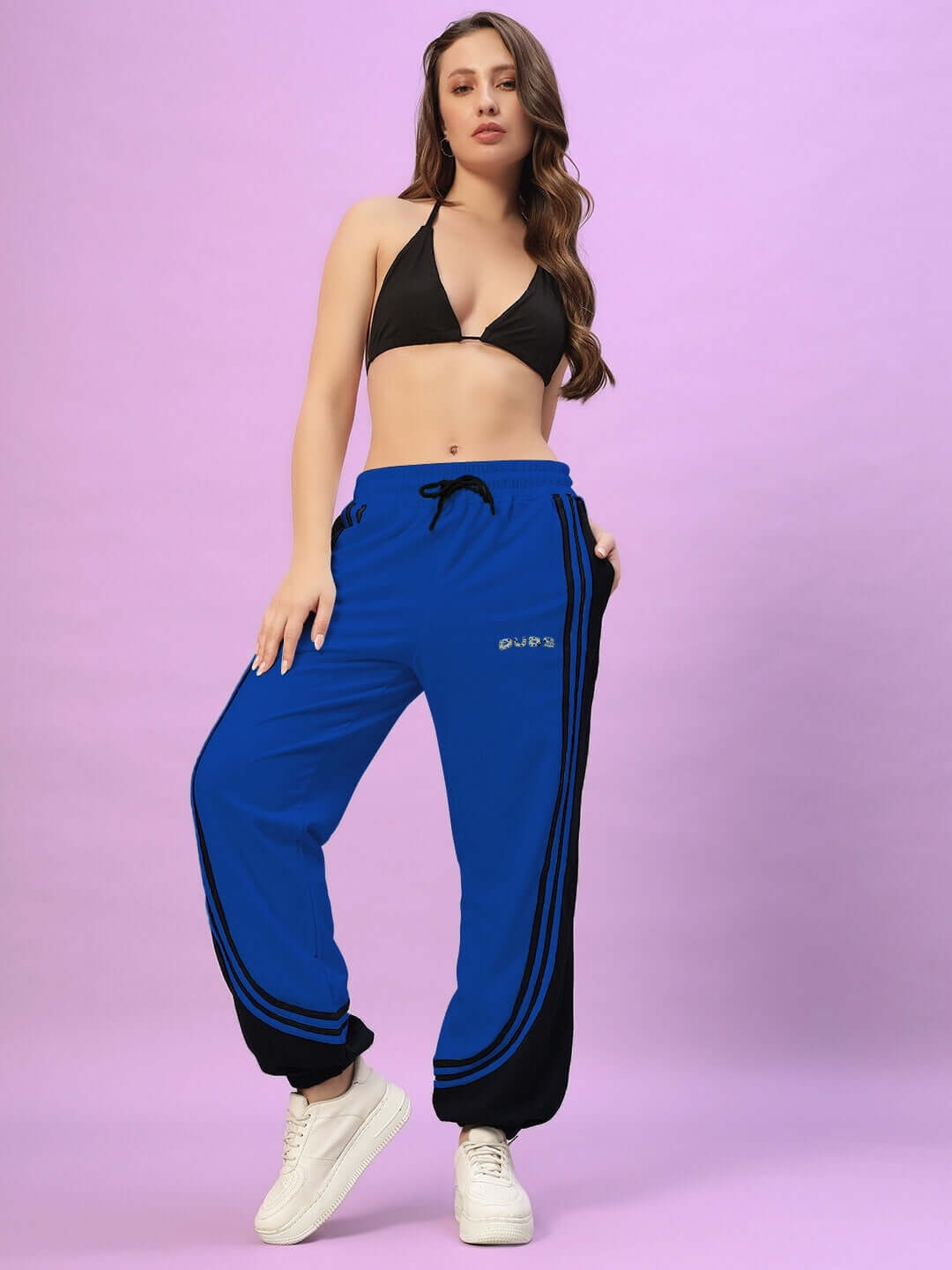Model wearing Women's Frenzy Curve Contrast Joggers in blue and black, showcasing its stylish design and comfortable fit for active wear.