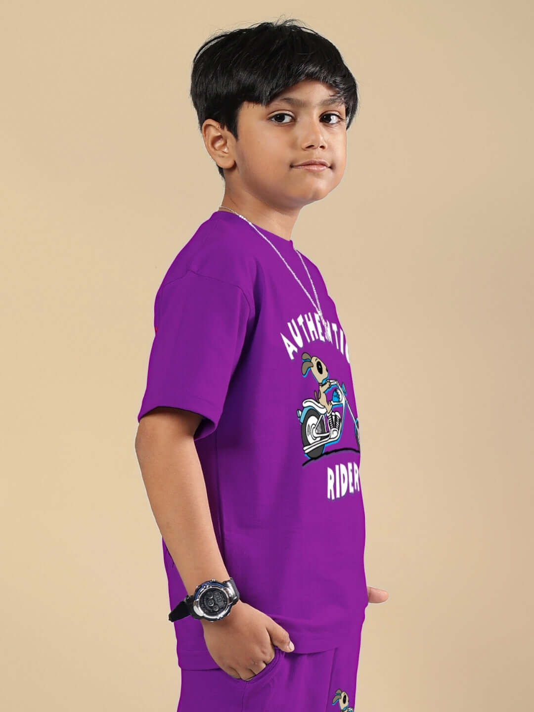 Boy wearing Authentic Rider T-Shirt in purple by DUDS, features unique graphic design, standing against neutral background.