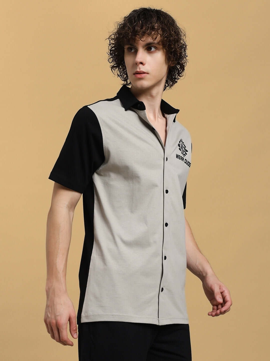 Model wearing TINGE regular fit grey-black shirt, short-sleeve, by DUDS, showcasing modern design and custom fit options.