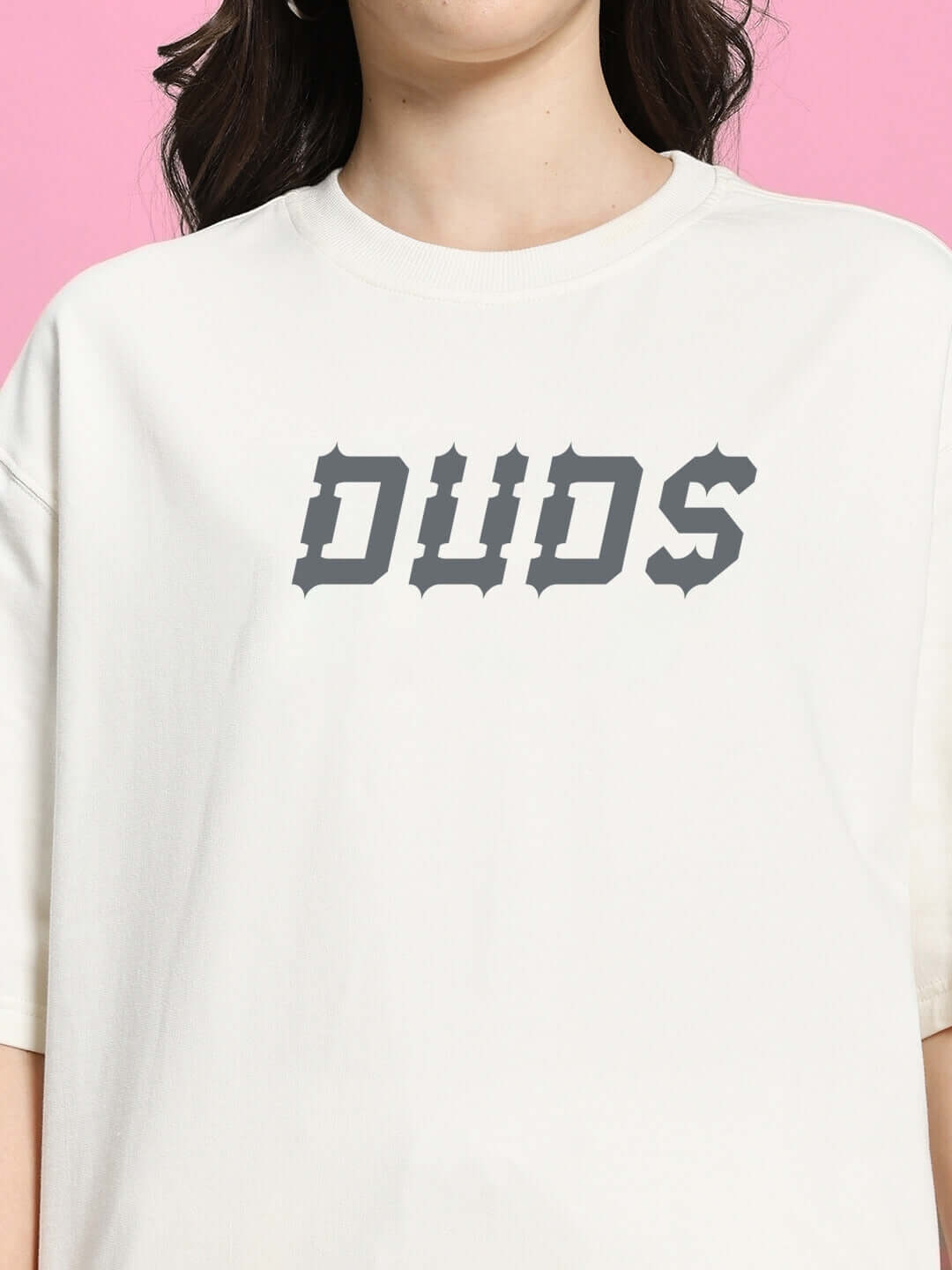 Women's oversized off white t-shirt with bold 'DUDS' graphic text on front, casual fashion style.