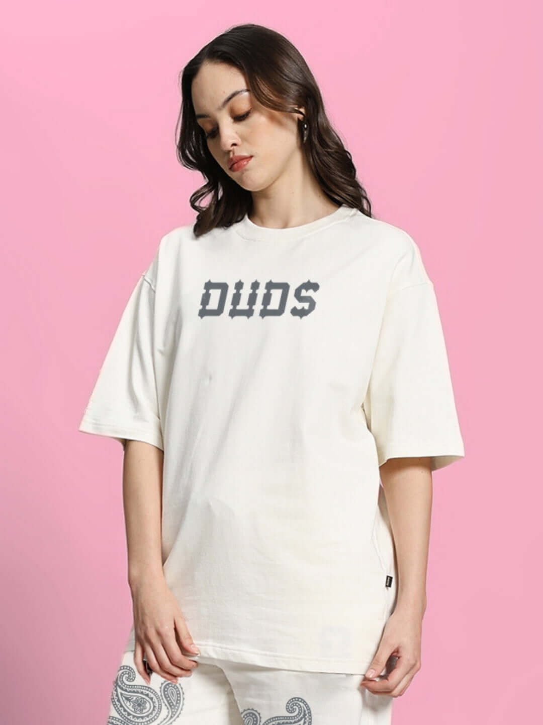 Woman wearing oversized off-white paisley print T-shirt made of premium cotton fabric, styled in a casual setting.