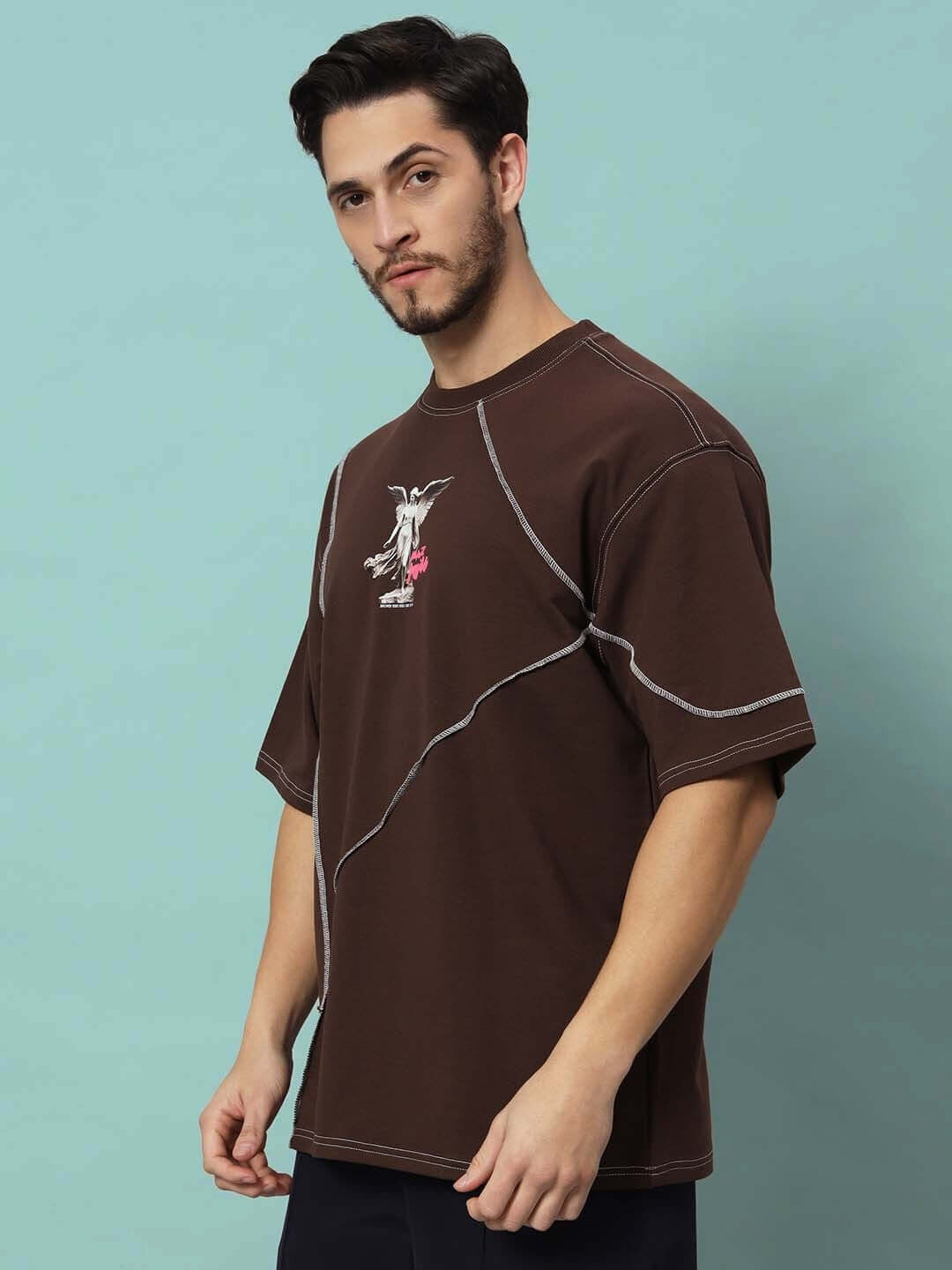 Person wearing MAKE IT POSSIBLE CONTRAST STITCHED OVER-SIZED T-SHIRT BROWN, featuring premium cotton fabric and unique design.