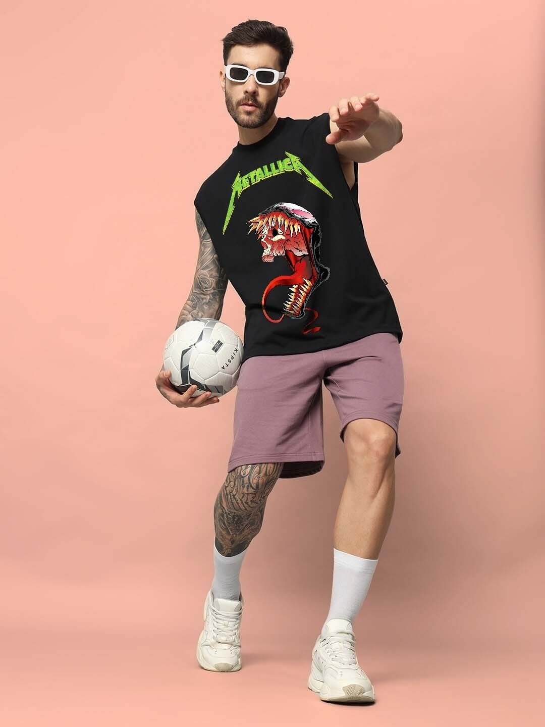 Young man in Carnage Gym T-shirt with soccer ball, styled for sports fashion on a pink background. Shop custom fit options online.