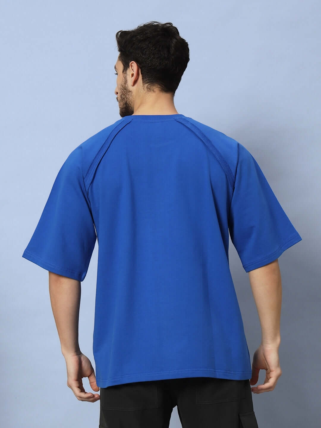 Back view of man wearing REGLAN DYING GOD OVER-SIZED T-SHIRT ROYAL BLUE with premium heavy gauge fabric.