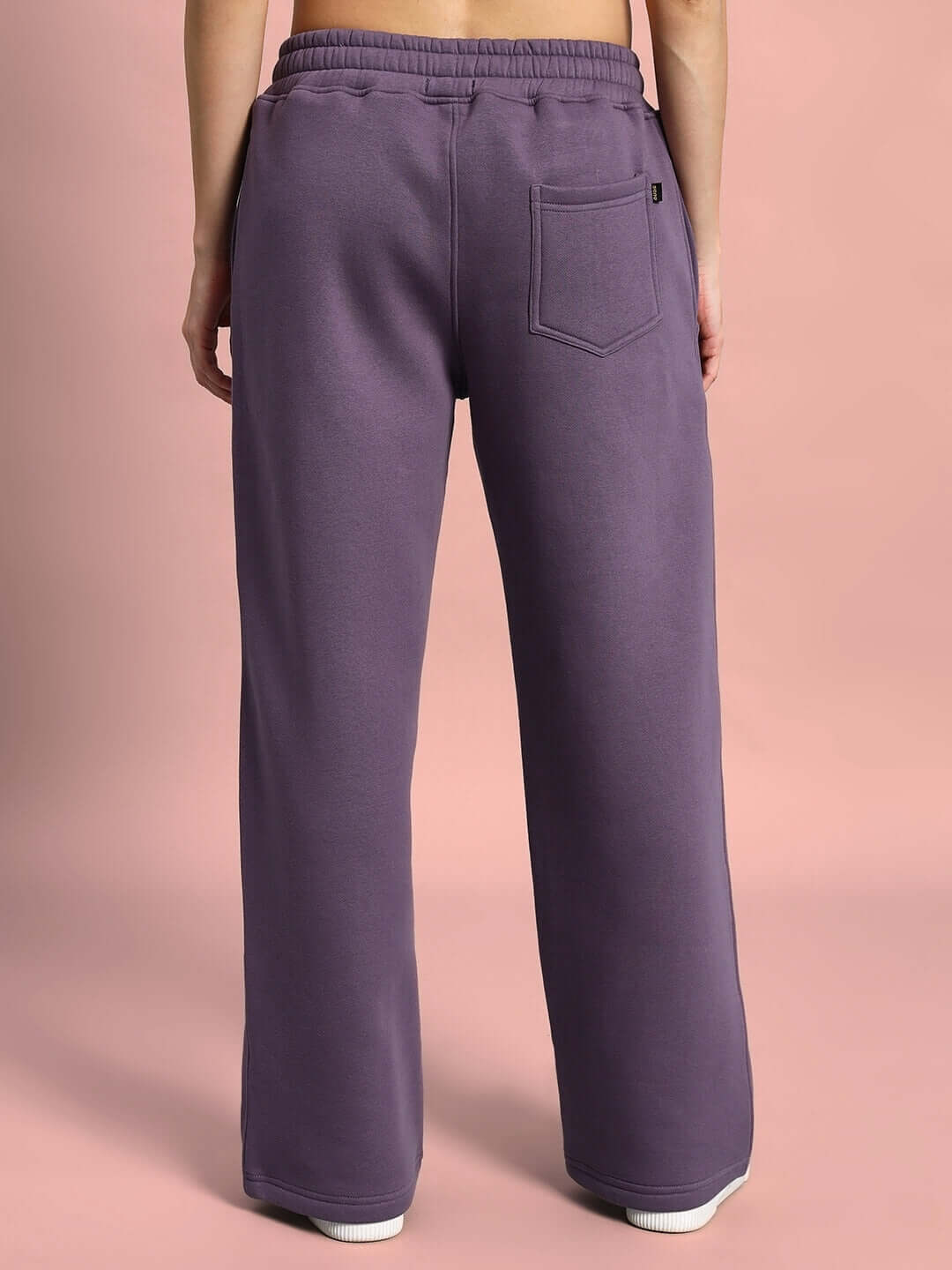 Back view of Women's Casper Fleece Jogger in Violet, featuring relaxed fit and comfortable waistband on a pink background.