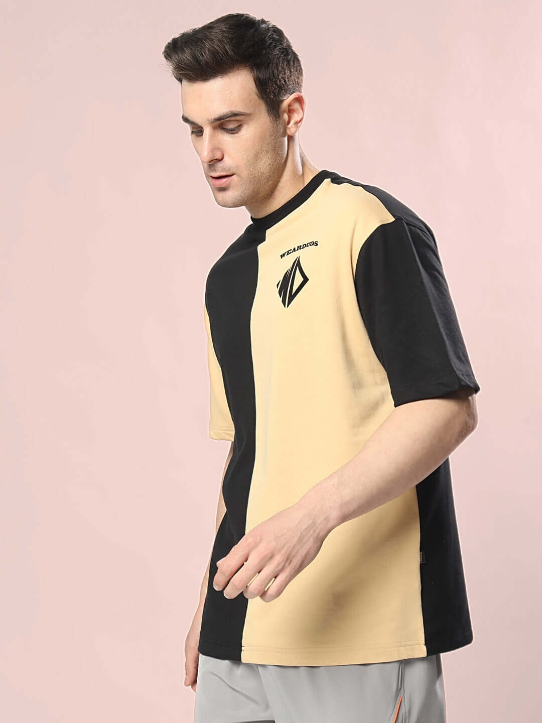 Man wearing DRAGON OVERSIZED T-SHIRT BLACK BEIGE, featuring premium cotton fabric blend for comfort and style on a light background.