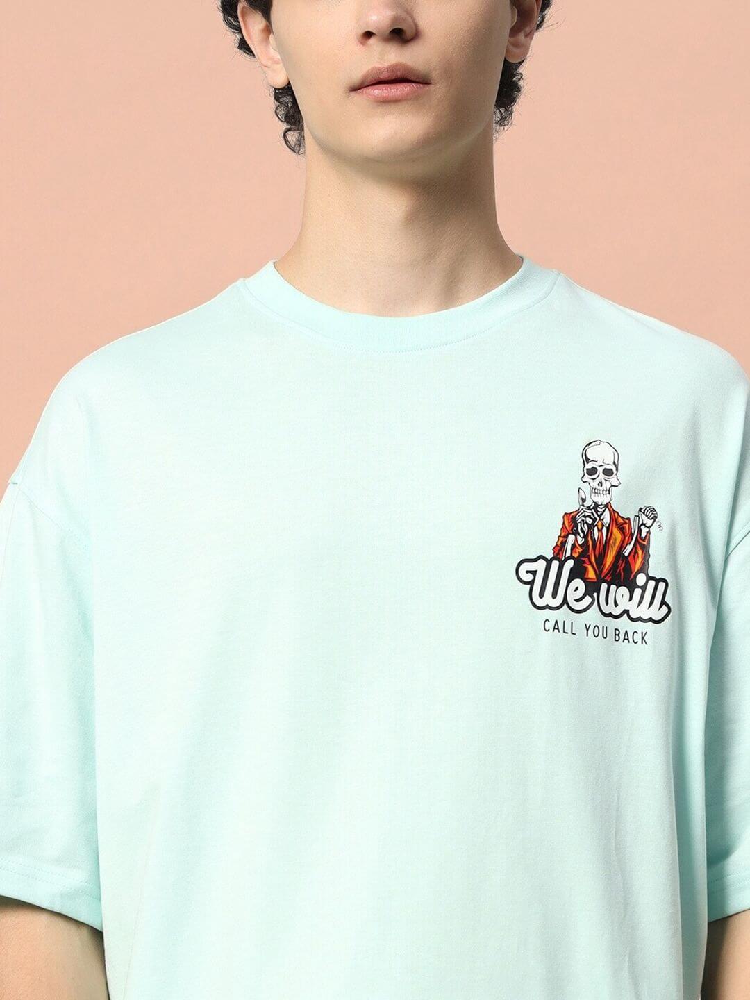 Person wearing CALL YOU BACK OVER-SIZED T-SHIRT ICE BLUE with skeleton graphic on chest, custom fit available for prepaid orders.