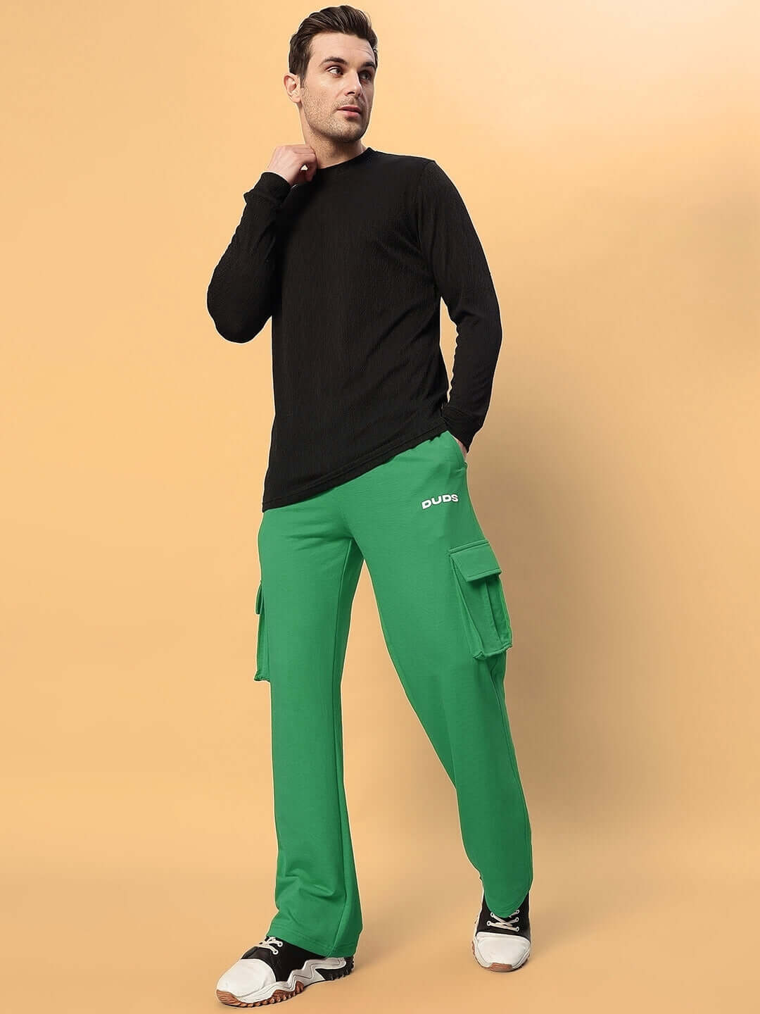 Model wearing green JESS 5 Pocket Relaxed Fit Joggers by DUDS, featuring cargo pockets, perfect for casual wear or custom fit options.