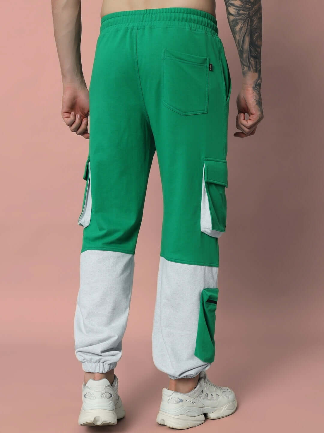 Back view of SKYSCRAPER RELAXED FIT CARGO PANT GREEN with white sneakers, showcasing pockets and design.