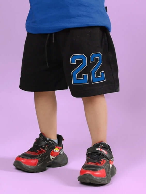 Child wearing black AMIGA shorts with blue number 22, featuring DUDS custom fit option for boys and girls, made to order.