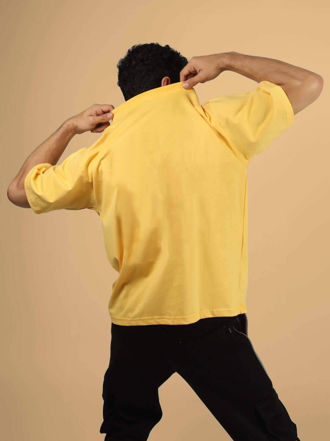 Back view of person wearing POPEYE OVER-SIZED T-SHIRT YELLOW, showcasing casual fit and vibrant color.