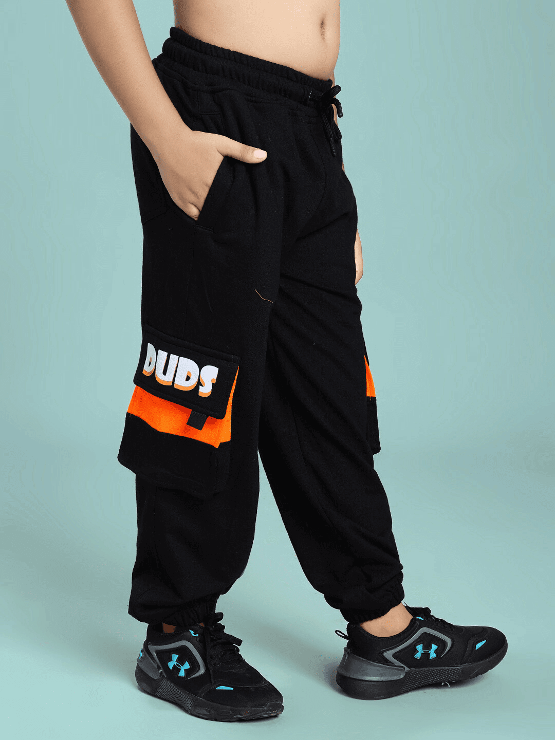 Child wearing TIGON KIDS CO-ORD SET FOR BOYS AND GIRLS ORANGE BLACK featuring sporty black pants with orange accents.