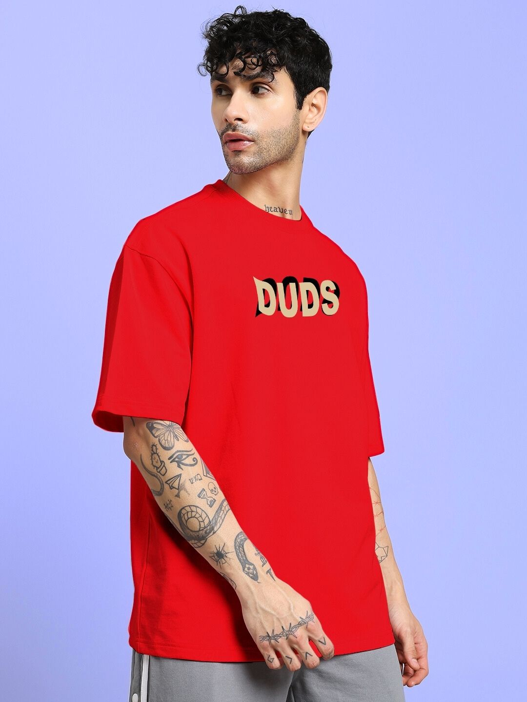 Person wearing KING OF SNAKE FUTURE PRINTED OVERSIZED T-SHIRT RED against a light purple background.
