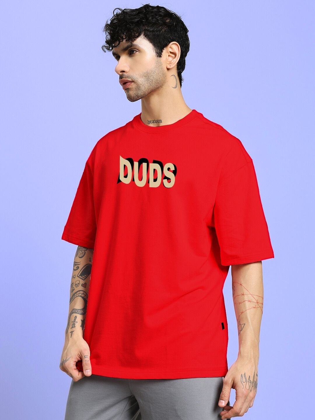 Man wearing KING OF SNAKE FUTURE PRINTED OVERSIZED T-SHIRT RED, standing against a blue background.