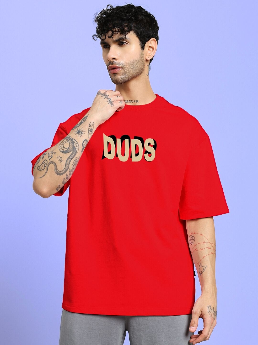 Man wearing KING OF SNAKE FUTURE PRINTED OVERSIZED T-SHIRT RED with 'DUDS' text design, bold style.