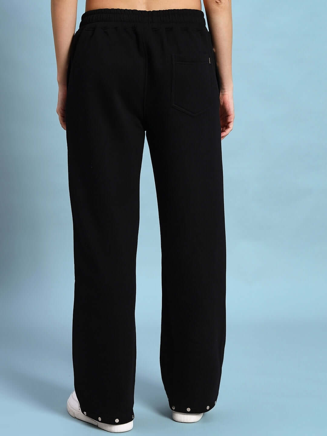 Woman wearing Women's Global Fleece Jogger in black, showcasing the back view and fit of the joggers against a blue background.