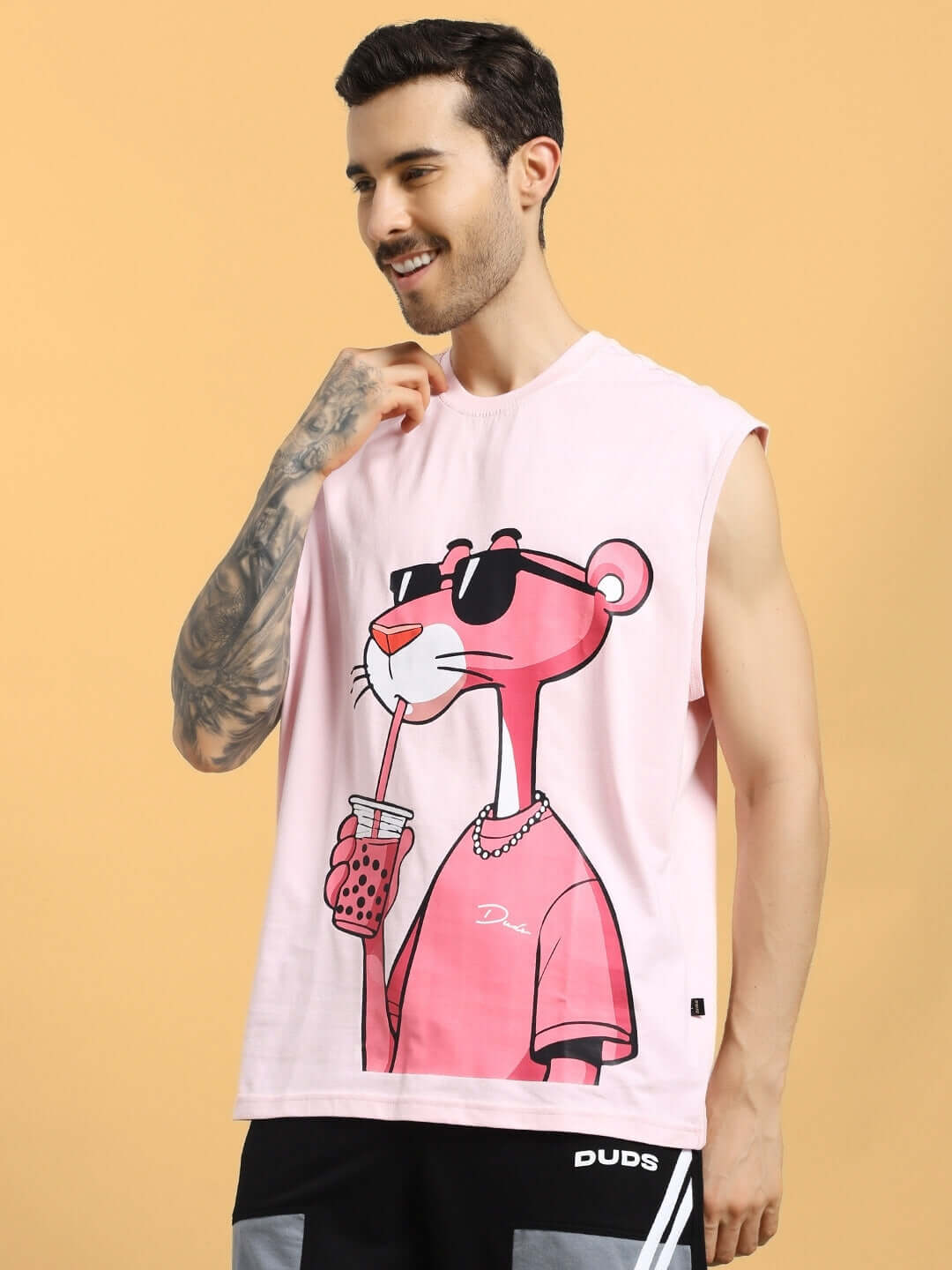Man wearing pink t-shirt featuring Pink Panther graphic with sunglasses, from DUDS' customizable collection.
