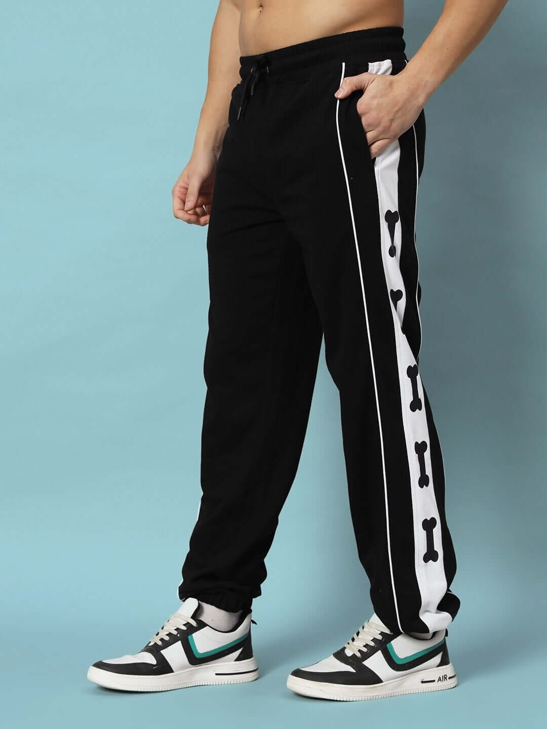 Model wearing TIBIA CONTRAST PANEL JOGGERS BLACK with bone design on sides, perfect for casual wear.