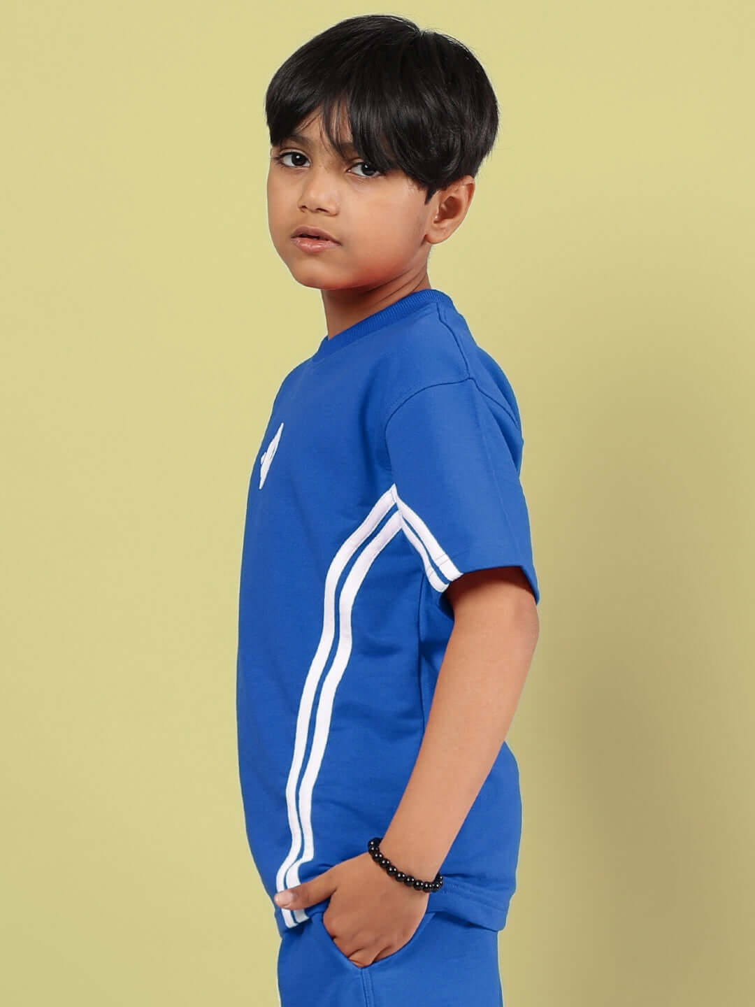 A young child wearing a stylish blue OUTLOOK T-shirt by DUDS, featuring white stripes on the side, perfect for boys and girls.