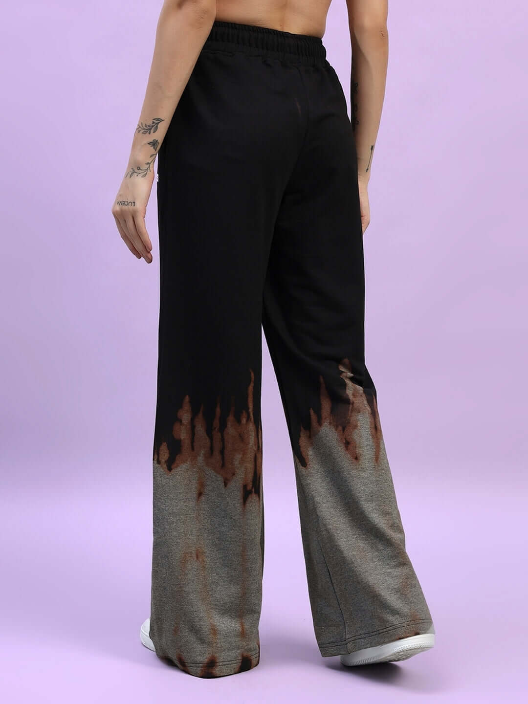 Back view of women's black tie-dye jogger pants with fire flame design, part of DUDS collection.