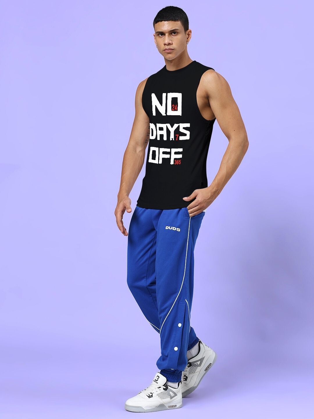 Man wearing NO DAYS OFF GYM CO-ORD SET BLACK ROYAL BLUE in a stylish and energetic gym outfit on light purple background.