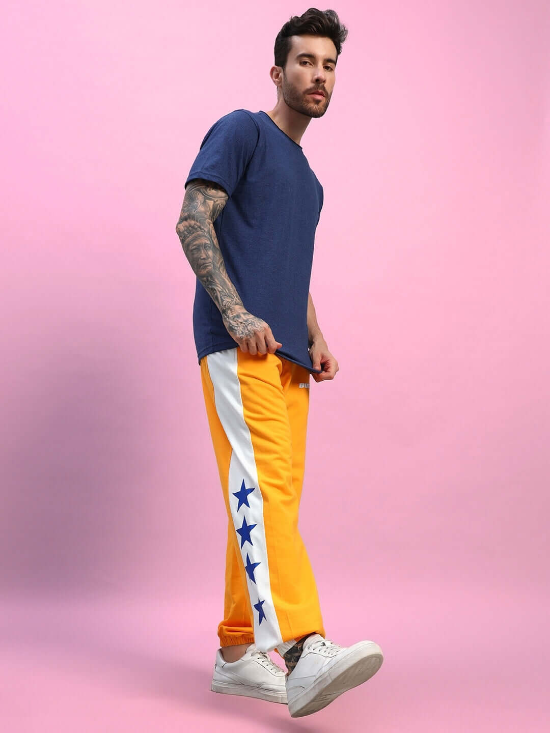 Model wearing ELEX navy blue regular fit t-shirt with yellow star-patterned pants, showcasing casual style.