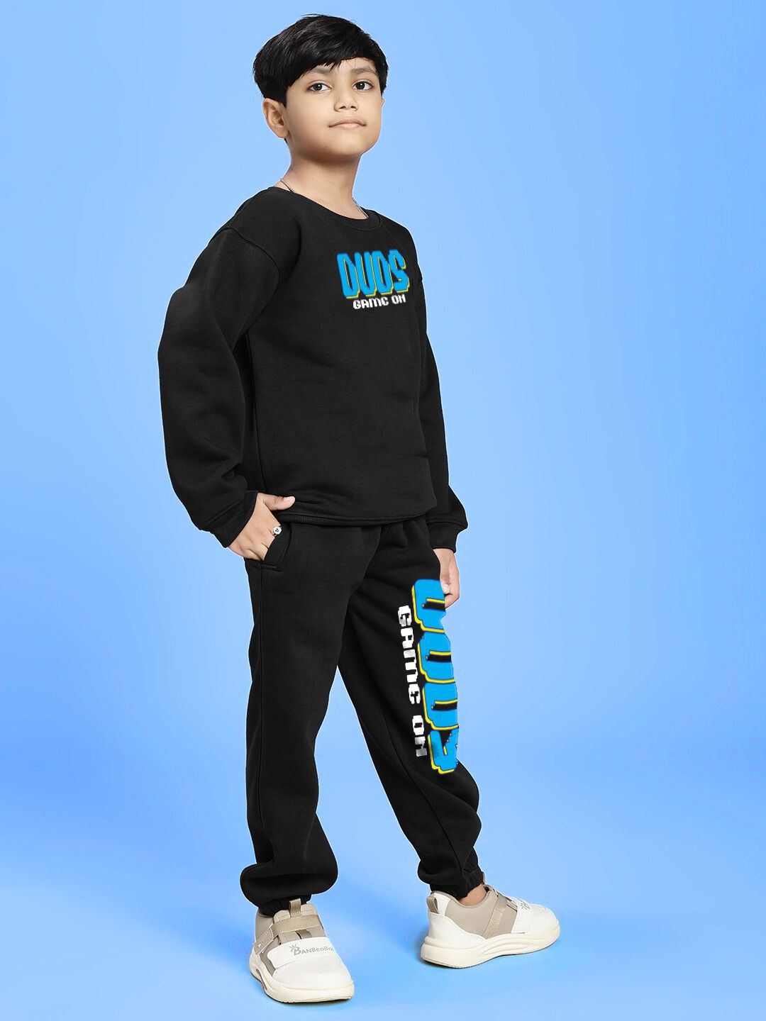 GAME ON PRINT FLEECE CO-ORD FOR BOYS AND GIRLS BLACK on confident young model against blue background
