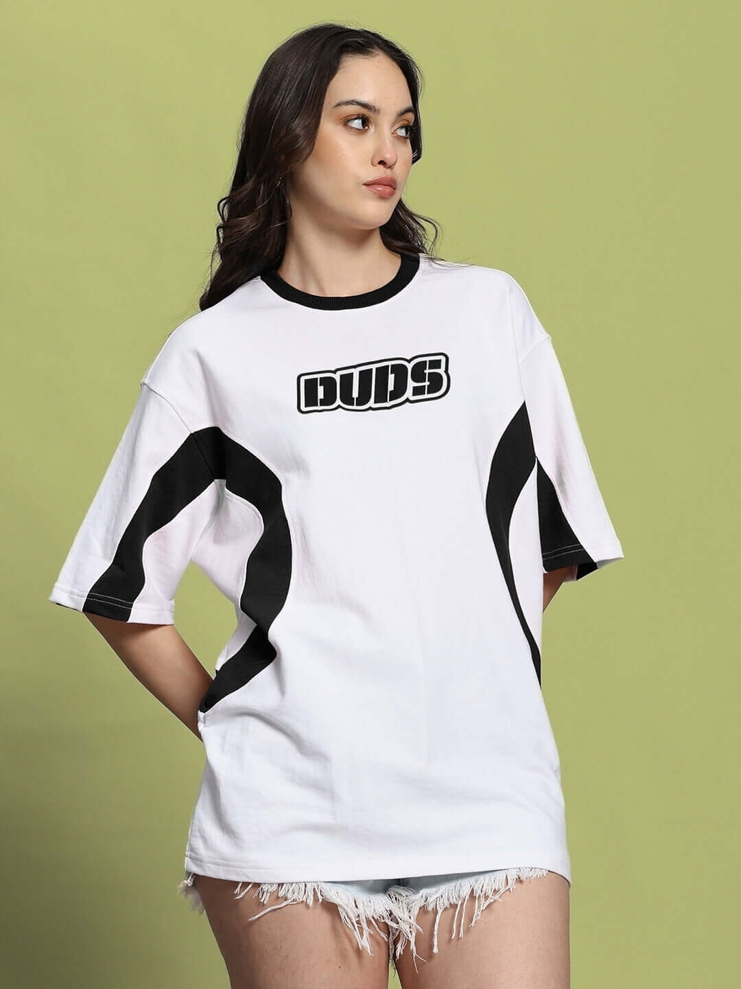 Woman wearing a women's white-black oversized T-shirt with 'DUDS' text, crafted from premium cotton and elastane blend.
