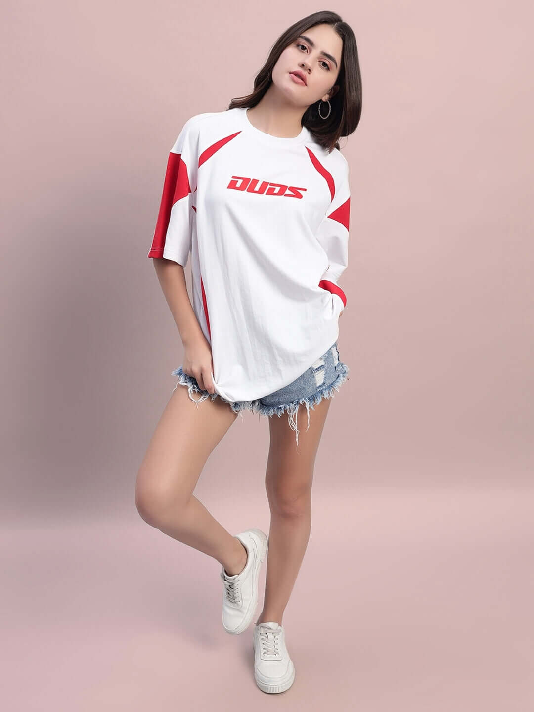 Women's oversized t-shirt in white and red with premium cotton material, styled with denim shorts for a casual look.