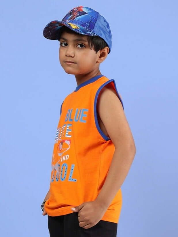 Child wearing orange Buffy T-shirt for boys and girls, paired with a blue cap, on a light blue background.