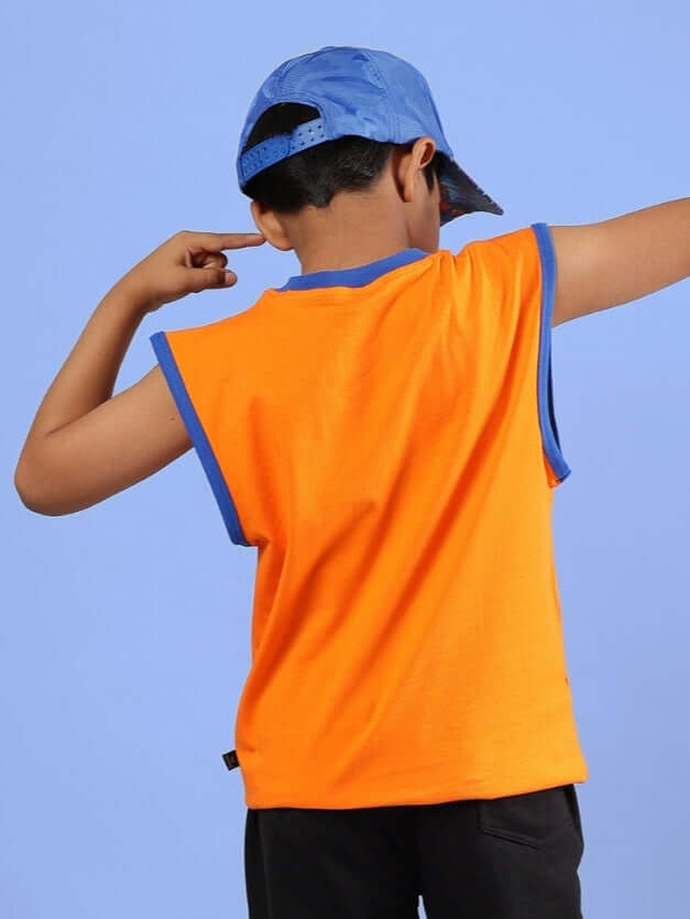 Child wearing an orange Buffy T-shirt for boys and girls, showcasing the back design, paired with a blue cap, against a blue background.
