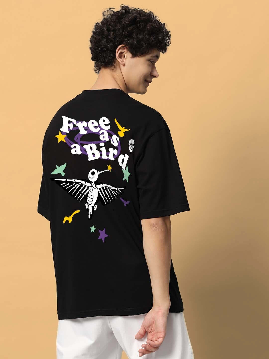 Model wearing FREE BIRD OVER-SIZED T-SHIRT BLACK with graphic design on the back, showcasing customization and comfort options