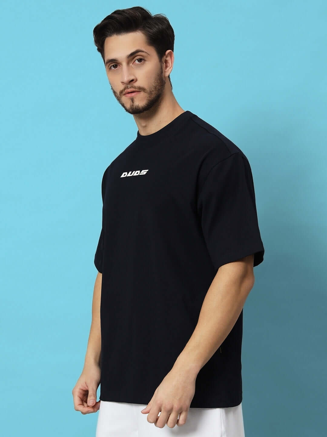 FLAME HOWL OVER-SIZED T-SHIRT NAVY BLUE on person with blue background showcasing front design.