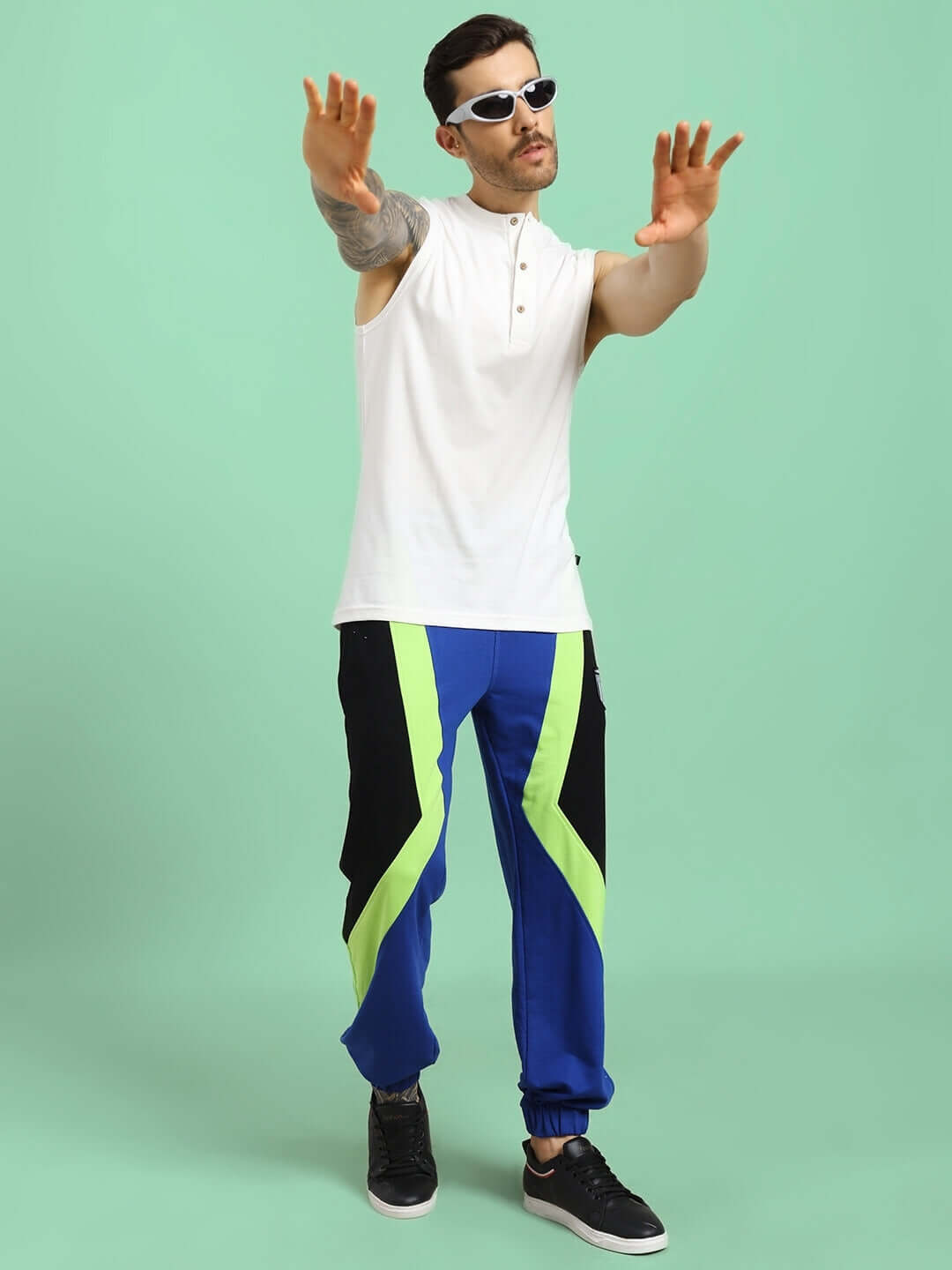 Model wearing off-white OLIN regular fit t-shirt made of premium heavy cotton slub fabric, styled with blue and green pants, standing confidently.