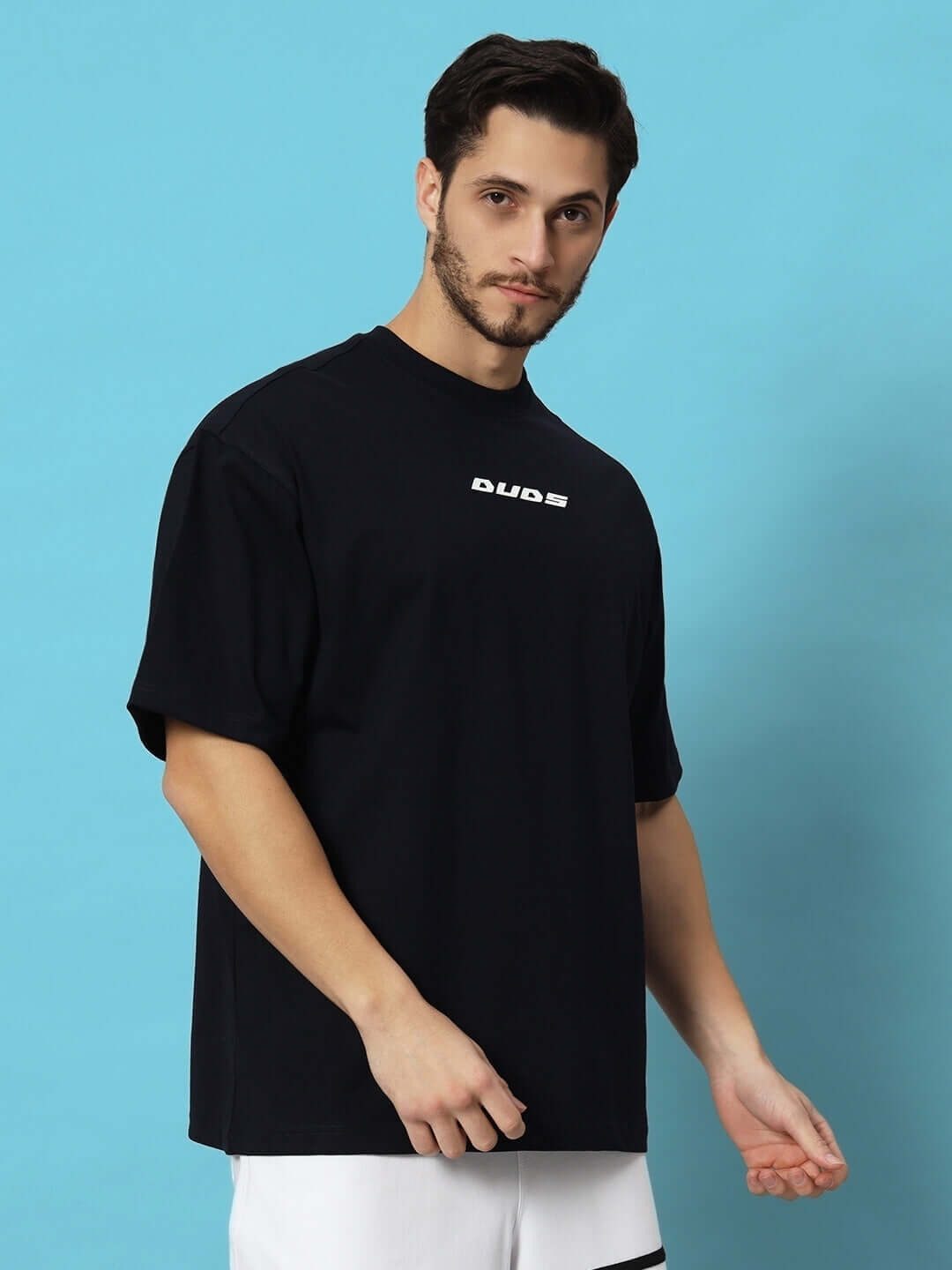 Model wearing FLAME HOWL OVER-SIZED T-SHIRT NAVY BLUE by DUDS against a blue background.