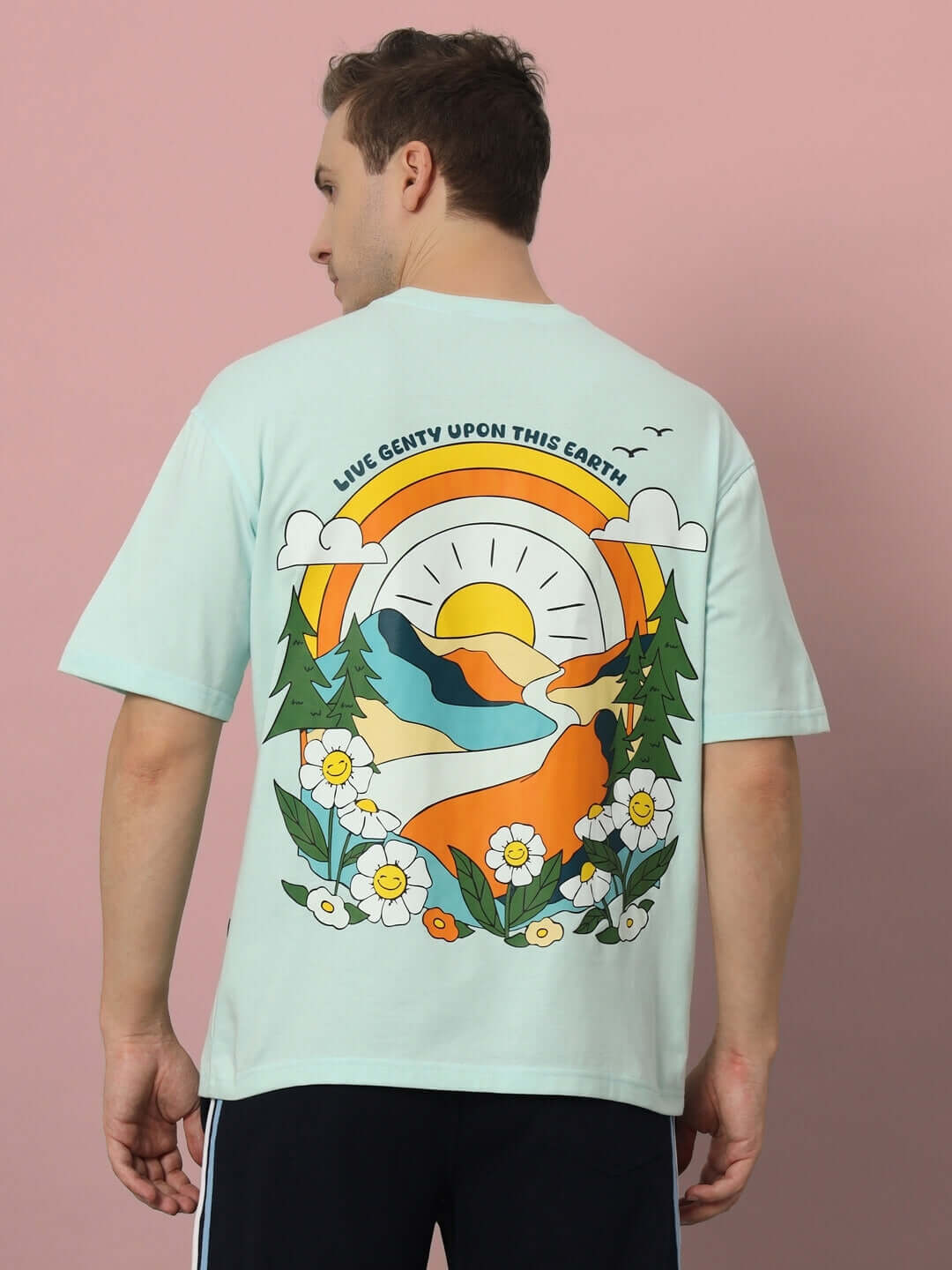 Man wearing LIVE GENTY UPON THIS EARTH OVER-SIZED T-SHIRT SKY BLUE with vibrant graphic design on the back.