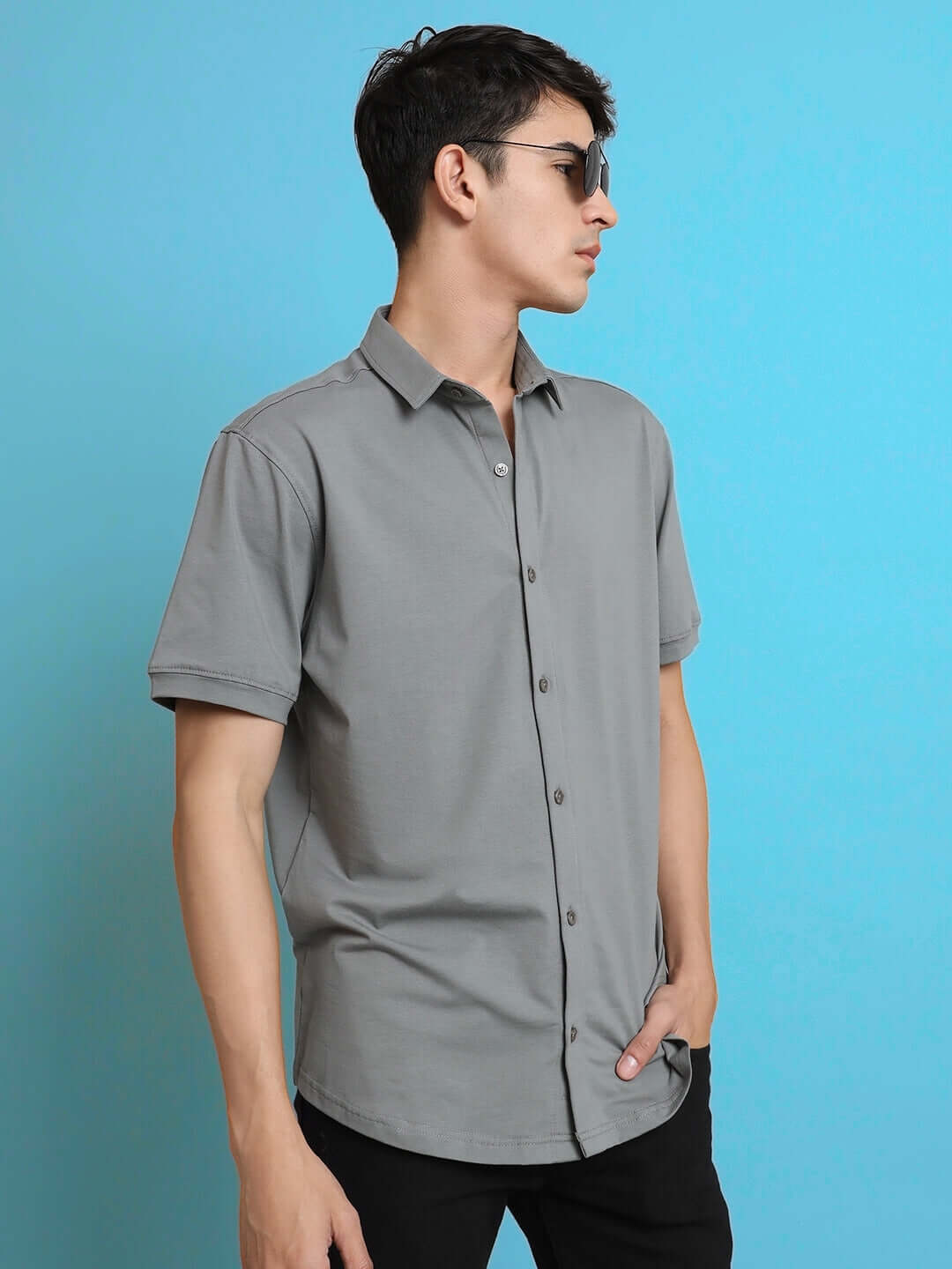 Model in Noir Grained Shirt, half sleeves, wrinkle-free, 4-way stretch cotton Lycra, slim fit, curved hem, comfortable for all-day wear.