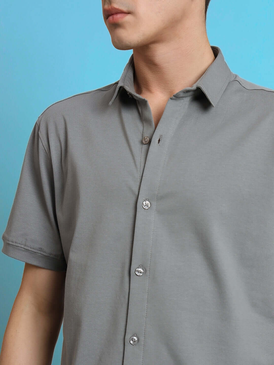 Man wearing a Noir Grained half-sleeve wrinkle-free shirt with curved hem, showcasing the comfortable slim fit and 100% cotton Lycra fabric.