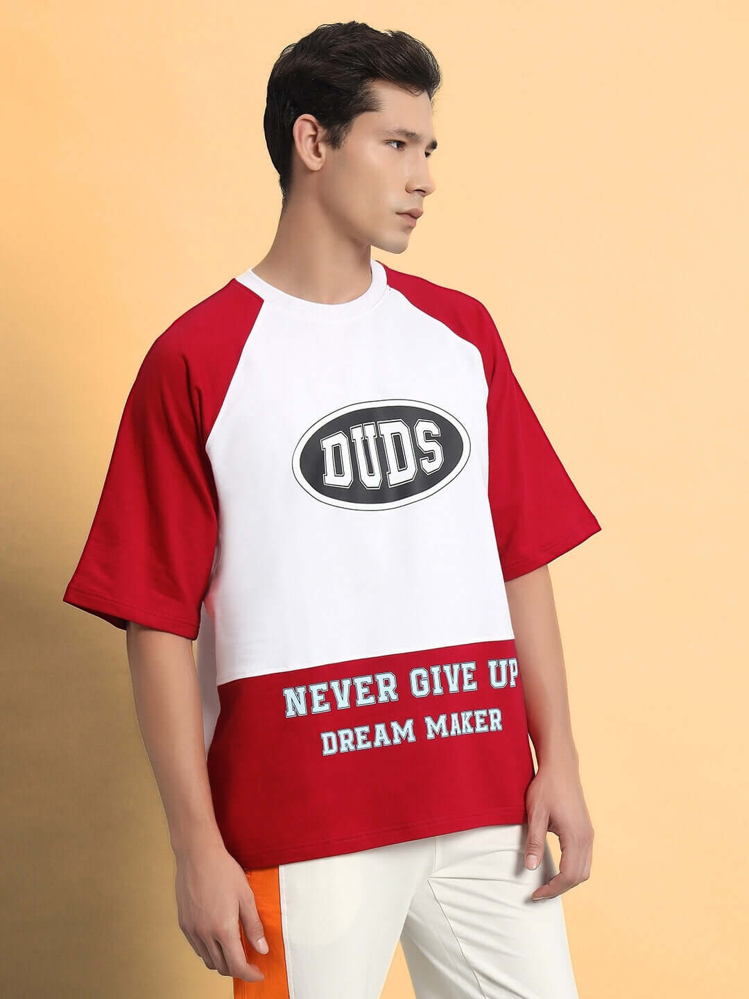 Model wearing NEVER GIVE UP OVERSIZED T-SHIRT RED made of premium cotton and elastane, showcasing unique design and bold colors.