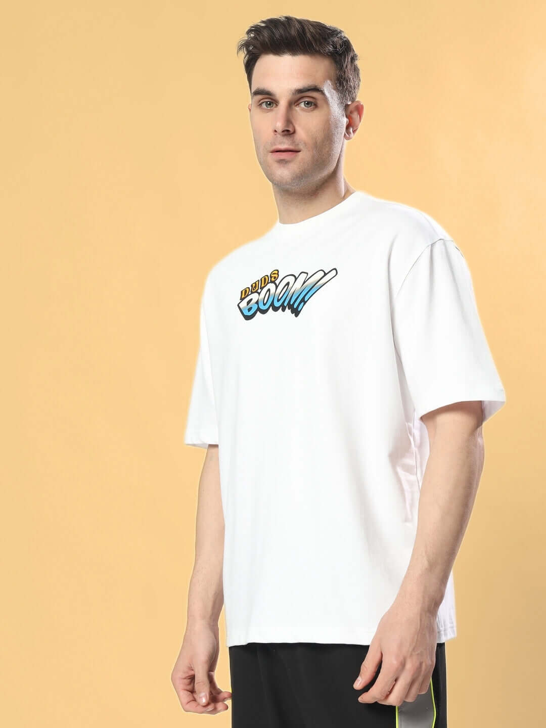Man wearing BOOM BUNNY OVER-SIZED T-SHIRT WHITE with graphic text on chest, against a light background.