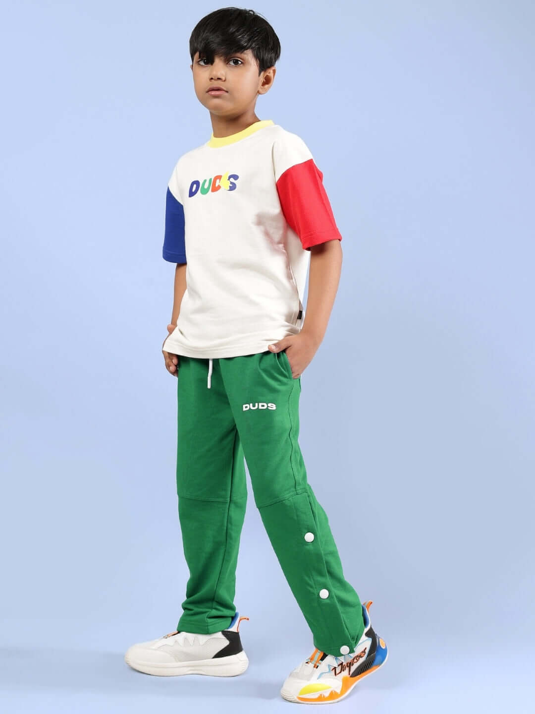 Child wearing ADONIS CO-ORD in off white and green by DUDS, featuring colorful sleeves and logo, made to order with custom fit option.
