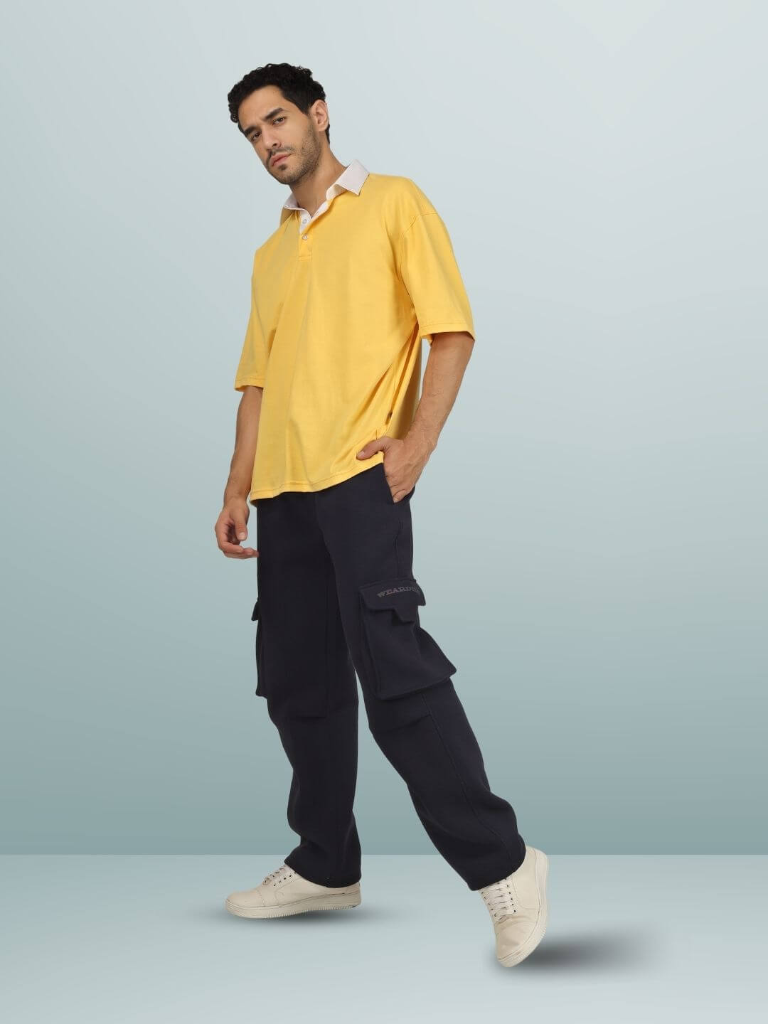 Man wearing 5 POCKET FLEECE SOLID CARGO PANT NAVY BLUE with yellow shirt
