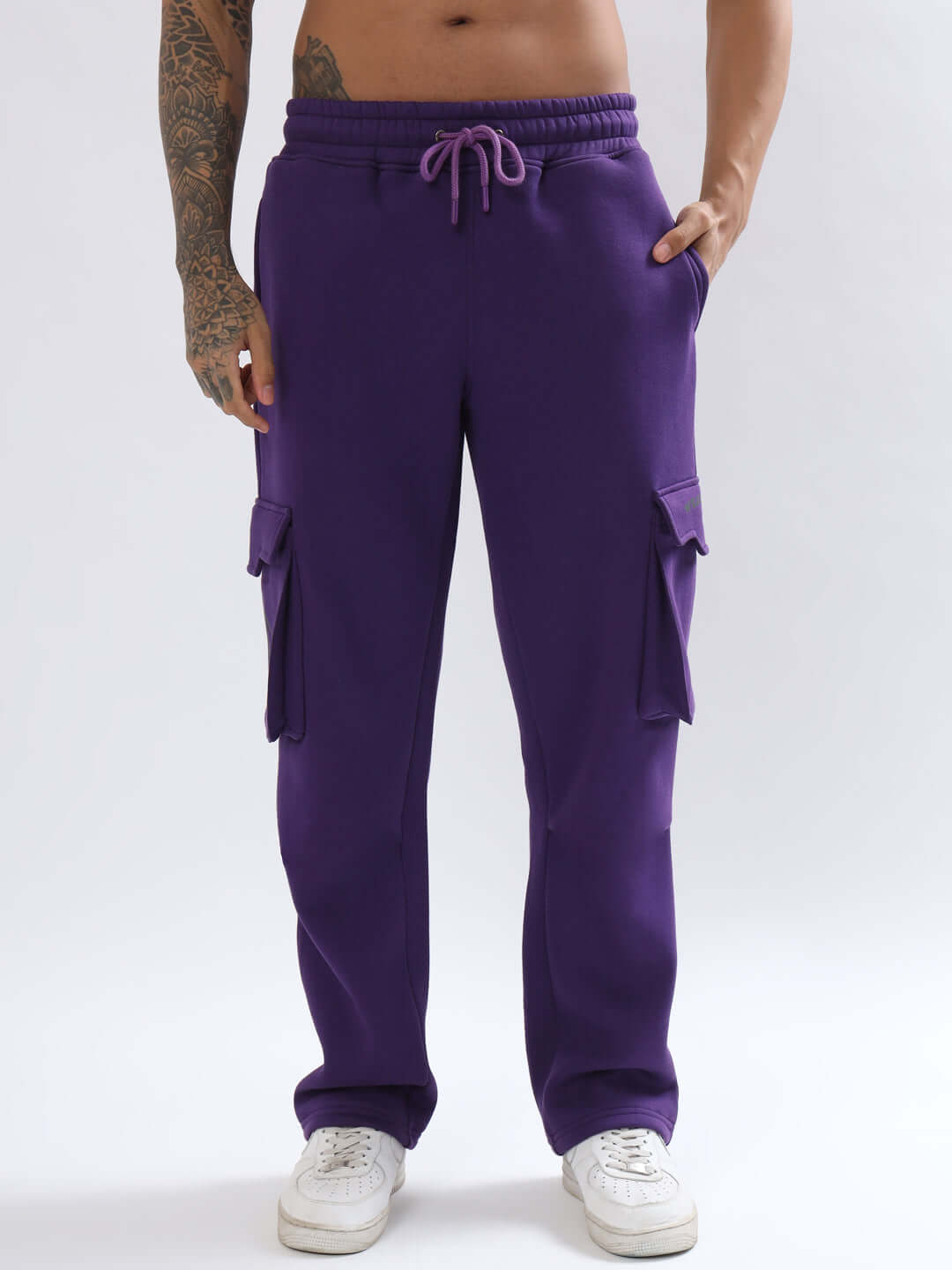 Person wearing 5 POCKET FLEECE SOLID CARGO PANT PURPLE with white sneakers, highlighting stylish comfort and functional pockets.