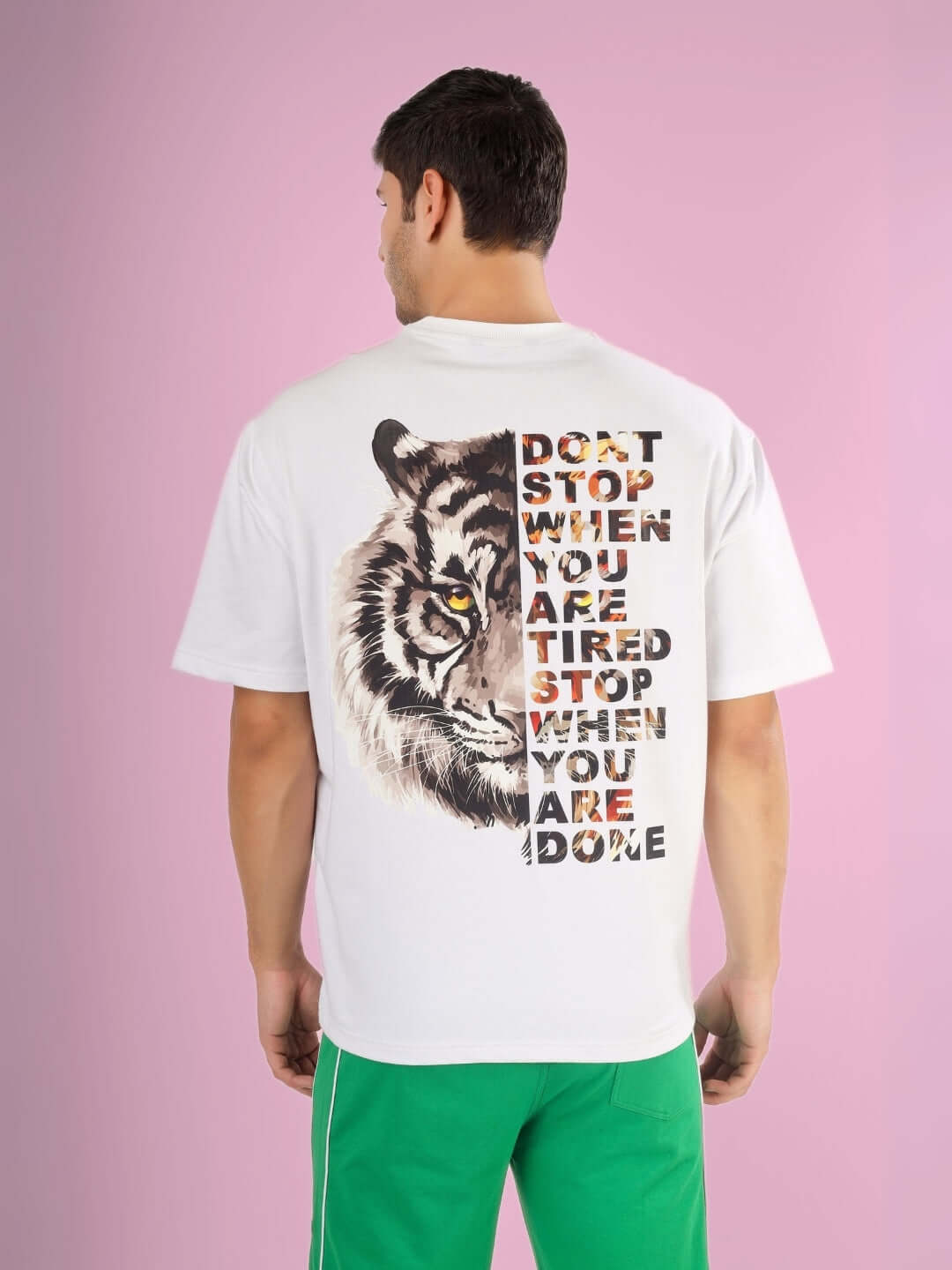 Man wearing DONT STOP OVER-SIZED T-SHIRT WHITE with motivational text and tiger design on the back, made of premium cotton and elastane blend.