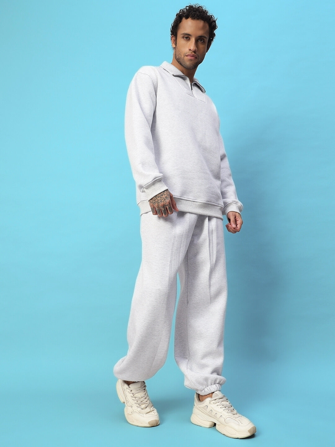 Model wearing Bona-Fide Fleece Pant in Melange Grey, showcasing comfort and style with premium fleece fabric, against a blue background.