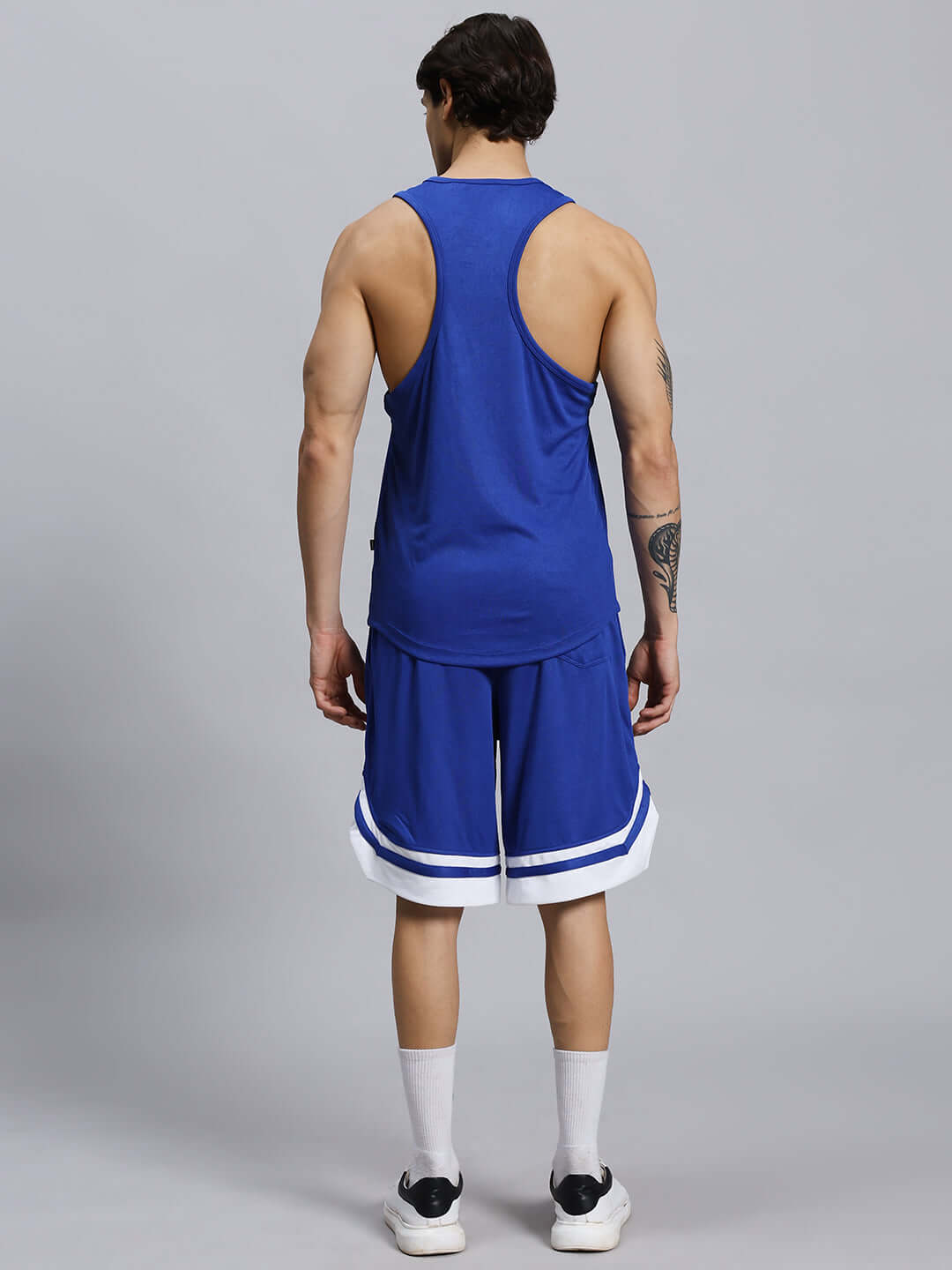 Rear view of a man wearing a royal blue WD Wings Gym Co-Ord Set, made of sports polyester, featuring a tank top and shorts.